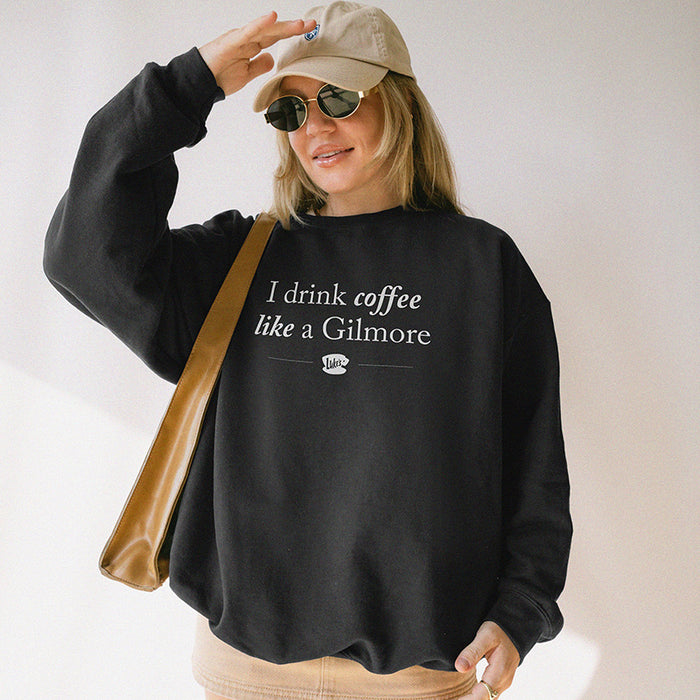 Model wearing black “I Drink Coffee Like a Gilmore” sweatshirt – unisex coffee lover pullover