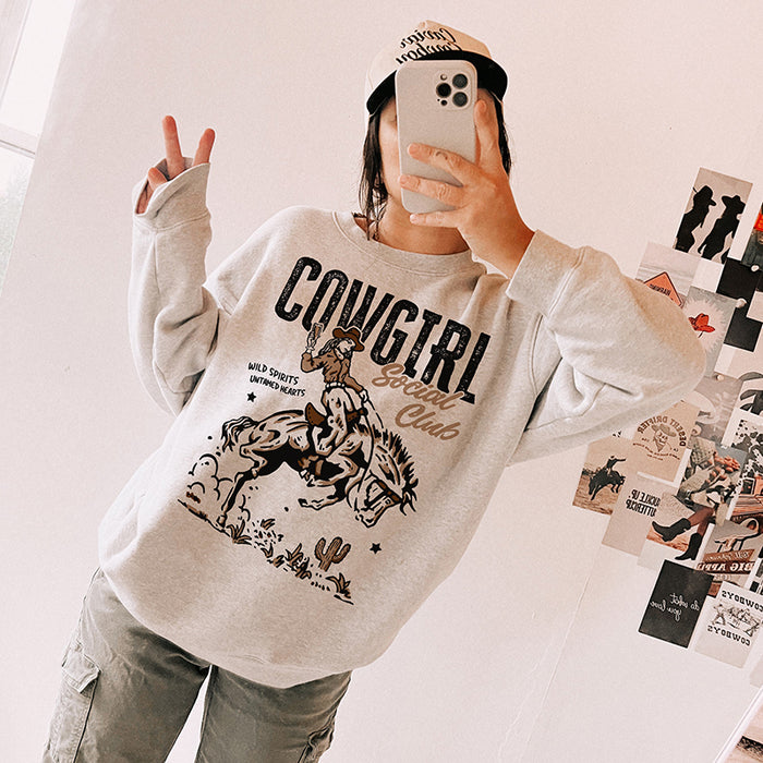 Cowgirl Social Club crewneck in ash — model wearing western sweatshirt with trucker hat