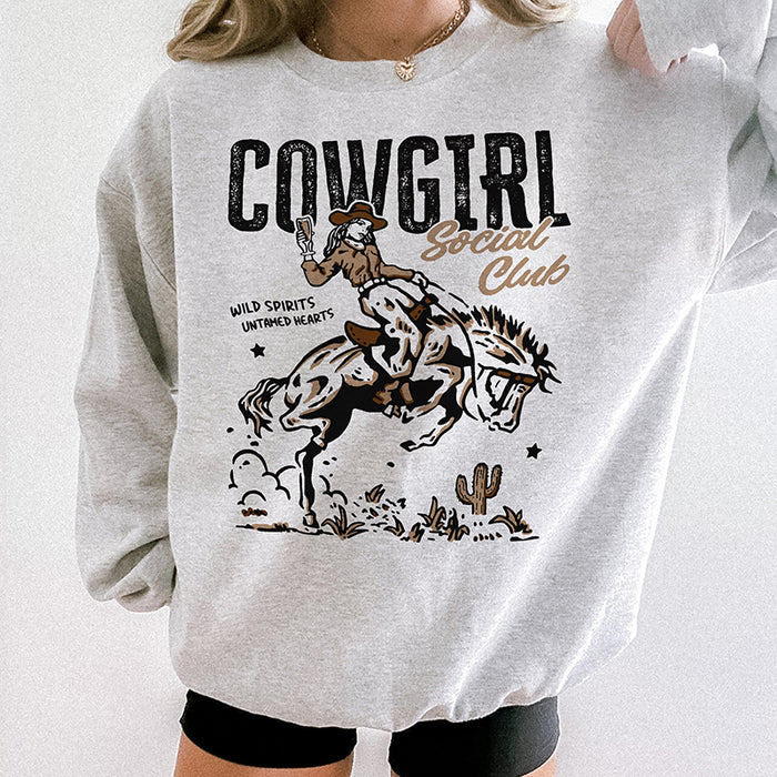Close-up of ash Cowgirl Social Club sweatshirt — retro graphic on cozy crewneck