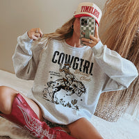 Model in ash crewneck styled with cowgirl boots and baseball cap — western sweatshirt outfit