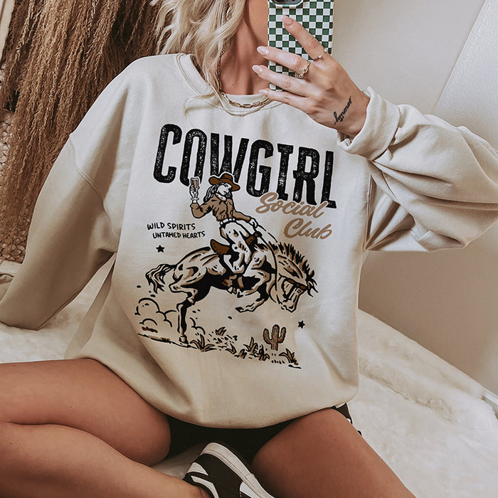 Model wearing Cowgirl Social Club crewneck in sand — women’s western graphic sweatshirt