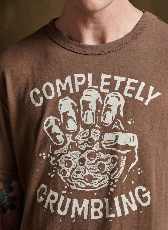 Close-up of male model wearing Pyknic's Completely Crumbling graphic tee. Cookie design shown clearly on soft cotton-blend shirt.