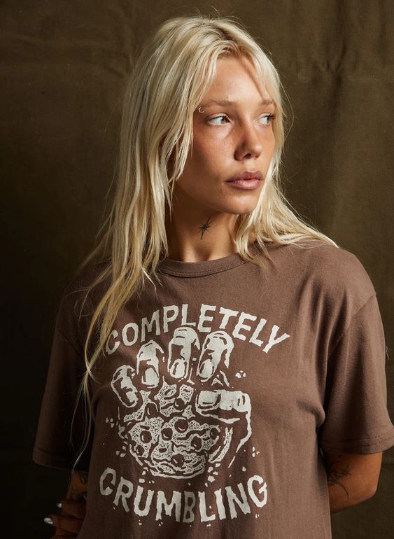 Front view of female model styling the Completely Crumbling graphic tee. Unisex fashion-fit shirt by Pyknic.