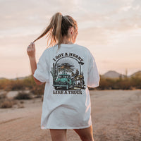Model standing in desert wearing Heart Like a Truck tee — relaxed fit country t-shirt with back print