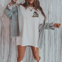 Model in denim jacket and cowboy boots wearing Heart Like a Truck tee — Lainey Wilson-inspired cowgirl outfit