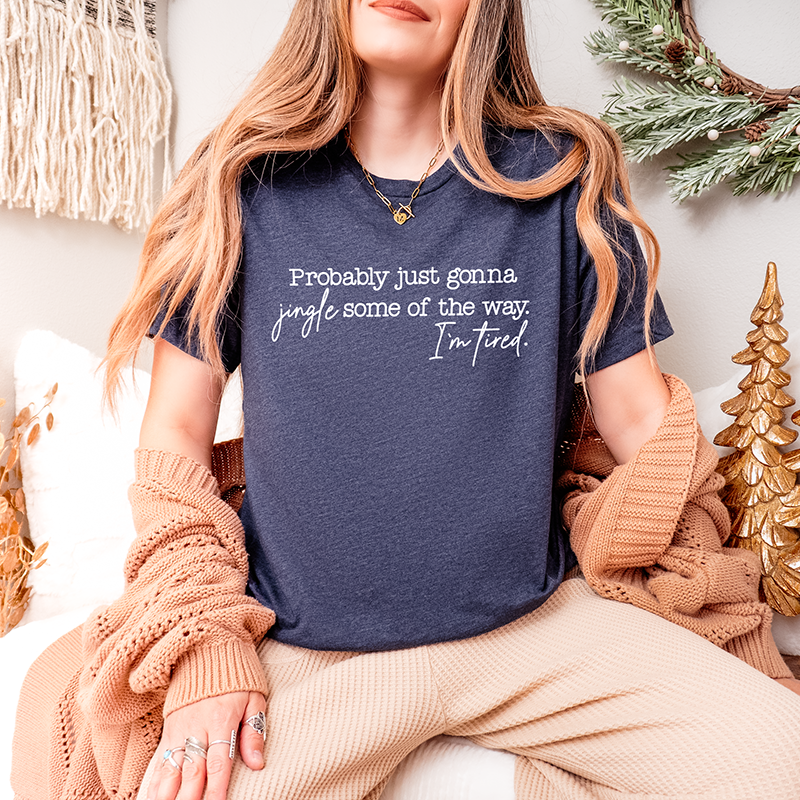 Woman wearing heather navy Christmas tee styled with winter décor – humorous festive unisex t-shirt