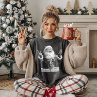 Woman wearing pepper Comfort Colors “Joyful Santa” Christmas tee, cozy oversized holiday outfit with plaid pajama pants