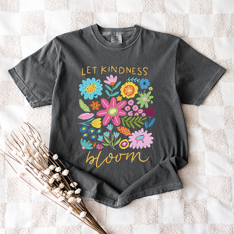 Flat lay of Let Kindness Bloom tee in pepper — kindness-themed floral shirt for women