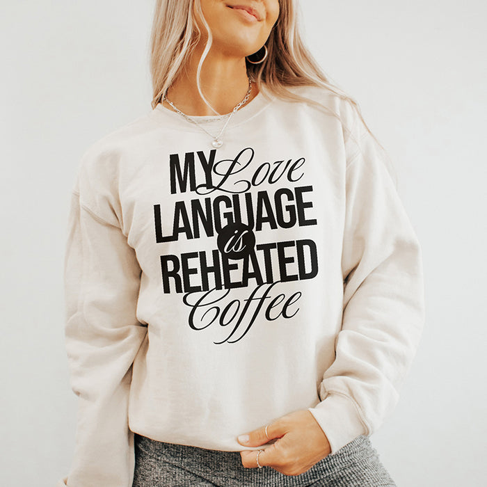 Model in the My Love Language Is Reheated Coffee sweatshirt in heather dust paired with cozy lounge pants — soft, relaxed, and perfect for WFH days.
