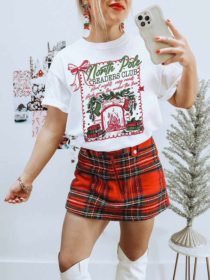 Heavyweight vintage-style Christmas tee for book lovers — North Pole Readers Club design with greenery and fireplace
