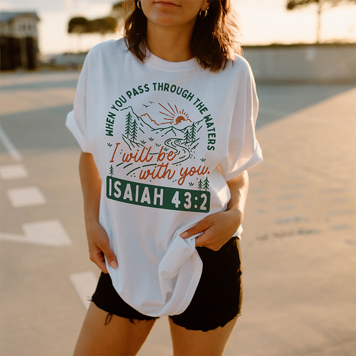 Model wearing Isaiah 43:2 tee — white Christian graphic t-shirt with mint and orange design